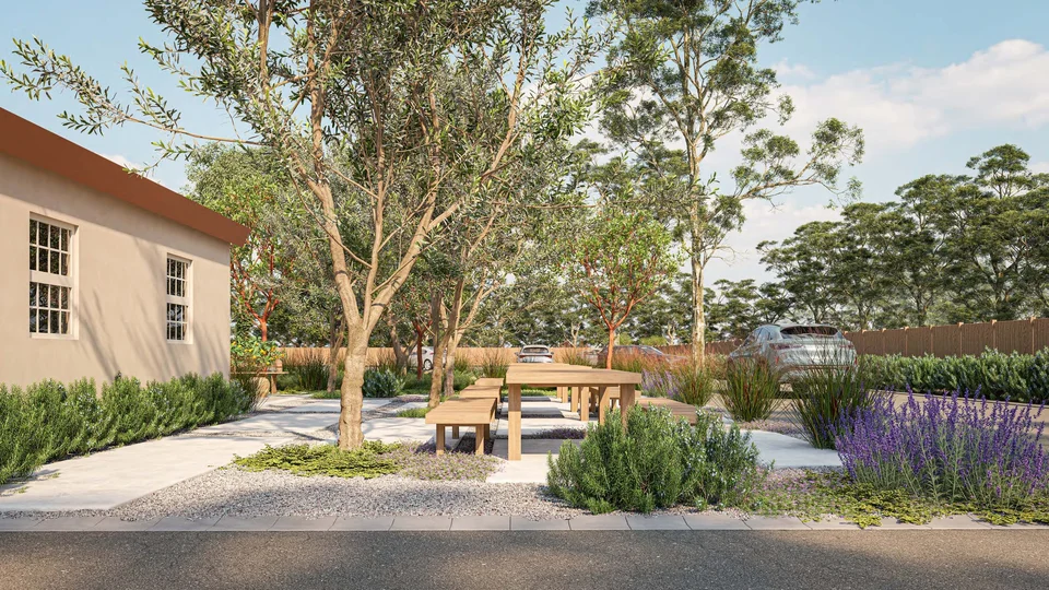 Rendering of wooden picnic tables under olive trees, edged with lavender and rosemary, between a stucco church building and the parking lot.