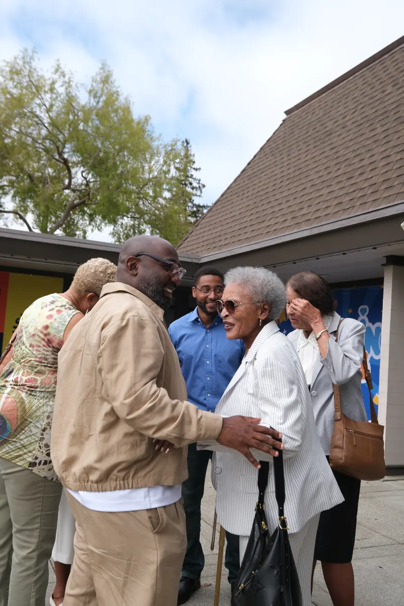 People of different generations greet each other outside the sanctuary.