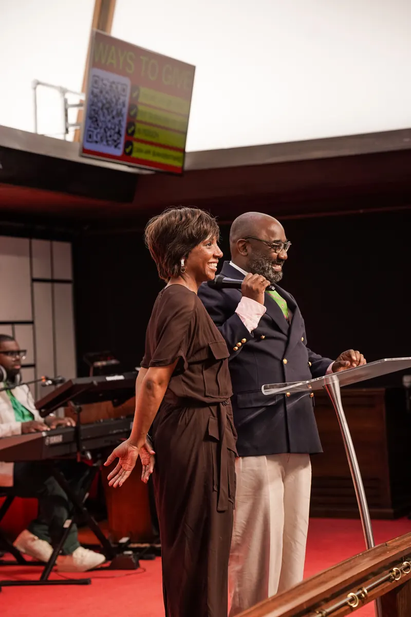 A man and an older woman smile together near the front of the sanctuary.